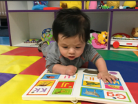 Baby looking at book on floor